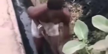 un homme présenté comme un présumé voleur contraint de curer un caniveau obstrué tout en étant forcé de danser
